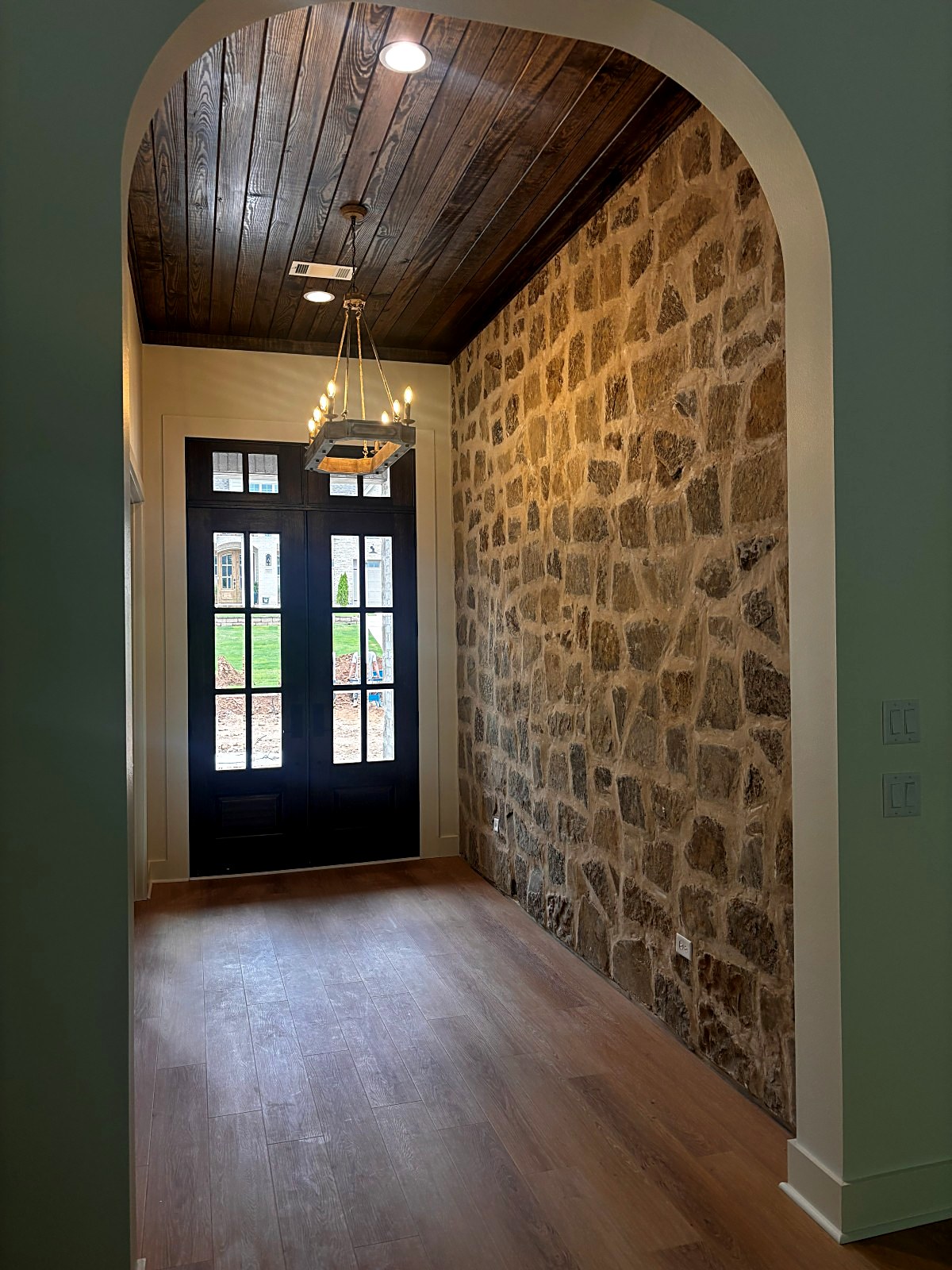 111 Bear Den Court &mdash; Arched stone entry hall with stained plank ceiling and iron lantern