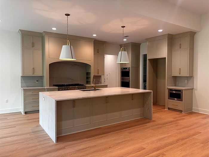 111 Bear Den Court &mdash; Kitchen with marble island, range alcove, and paneled cabinetry
