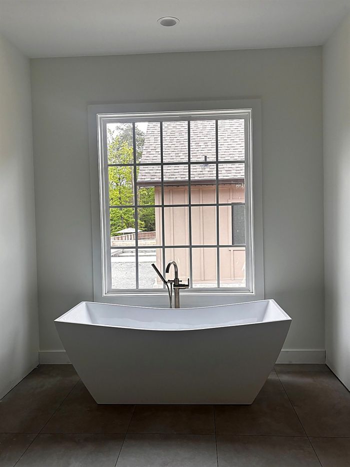 111 Bear Den Court &mdash; Freestanding soaking tub beneath a divided-light window