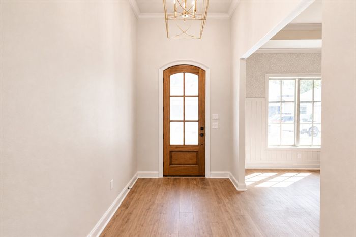 114 Kinley Loop — Entry foyer with arched wood door and lantern pendant
