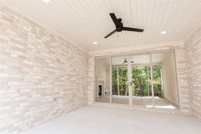 114 Kinley Loop — Room with painted brick accent wall and shiplap ceiling