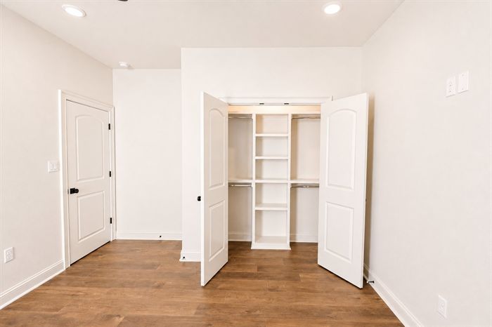 114 Kinley Loop — Bedroom with double-door closet and hardwood floors