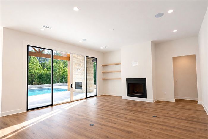 115 Bear Den Court &mdash; Living room with fireplace and sliding doors to the pool