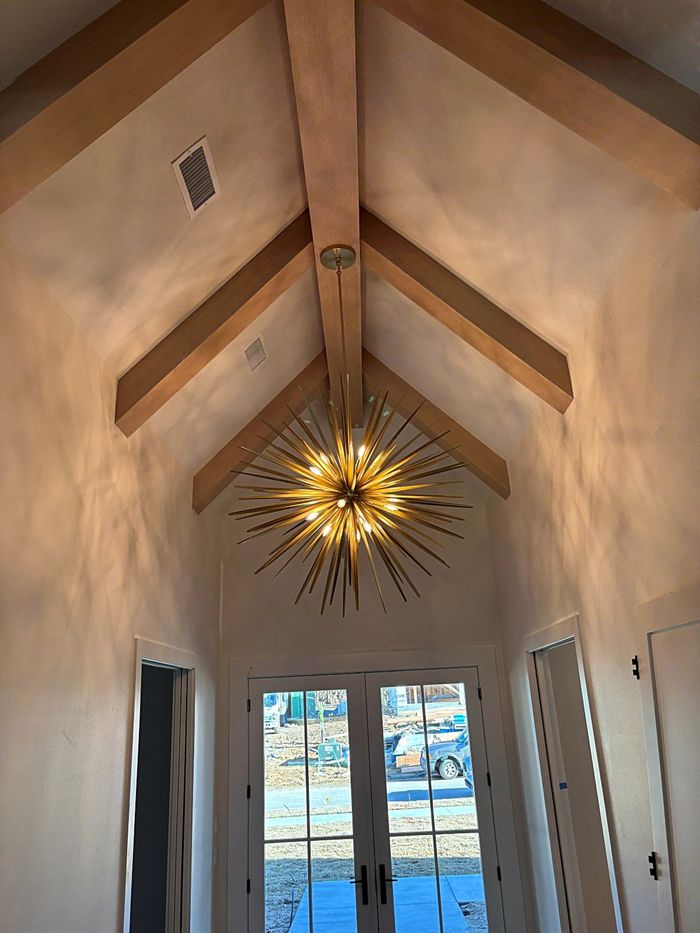 115 Bear Den Court &mdash; Vaulted hall with exposed timber and starburst chandelier