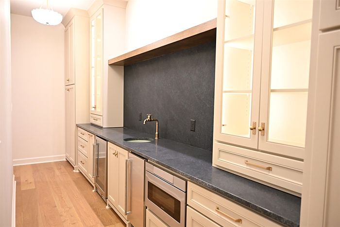 217 Abington Circle &mdash; Butler pantry with honed backsplash and glass cabinets